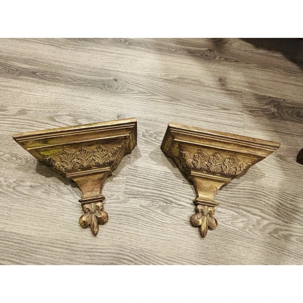 Vintage gold-toned decorative wall shelves with floral motifs.